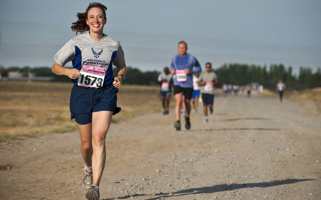 Smiling woman running in a footrace
